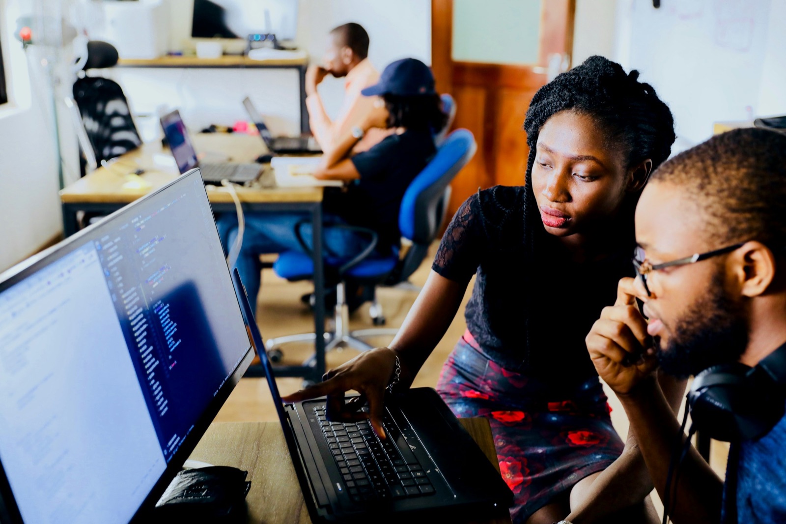 Two Soluteck engineers working through a problem together at a shared screen in Accra