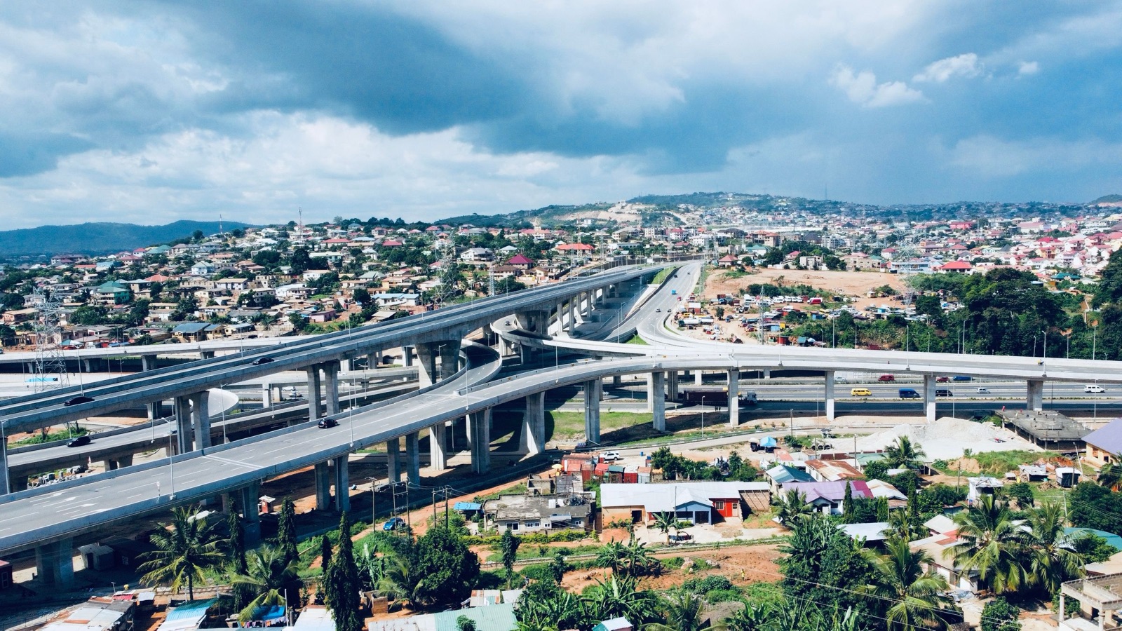 Aerial view of an Accra highway interchange under dramatic clouds
