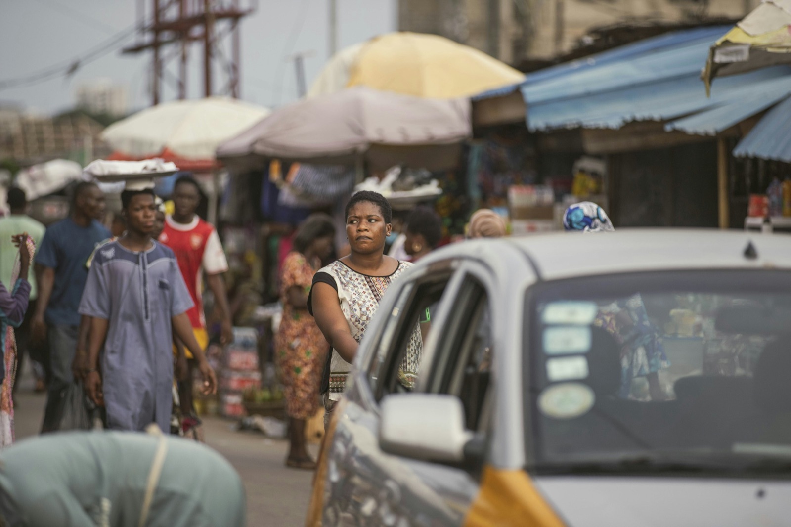 A busy Accra street with taxis and market umbrellas