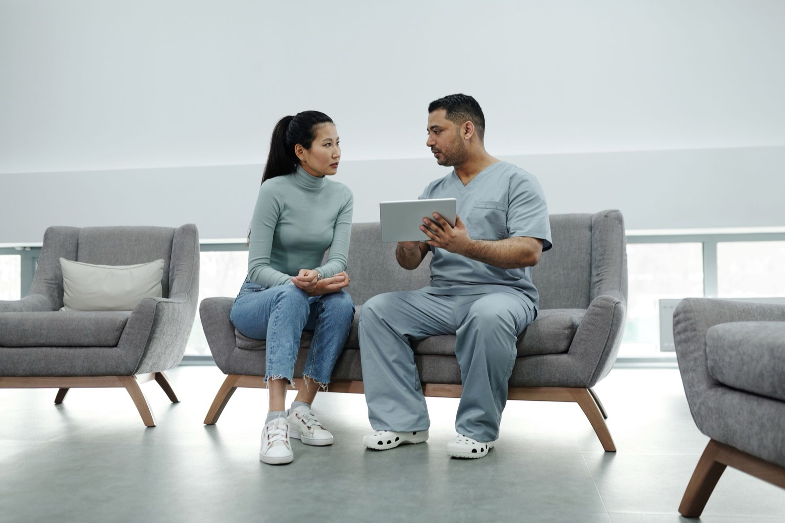 A clinician in conversation with a patient across a consulting-room desk